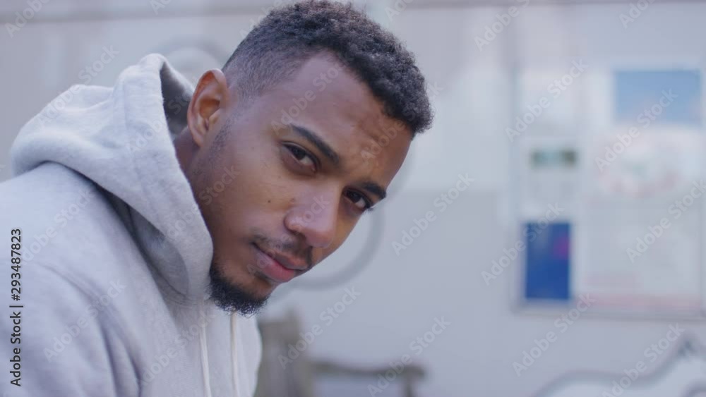 Portrait of handsome young black male looking to camera and smiling, in slow motion Portrait of handsome young black male looking to camera and smiling, in slow motion
