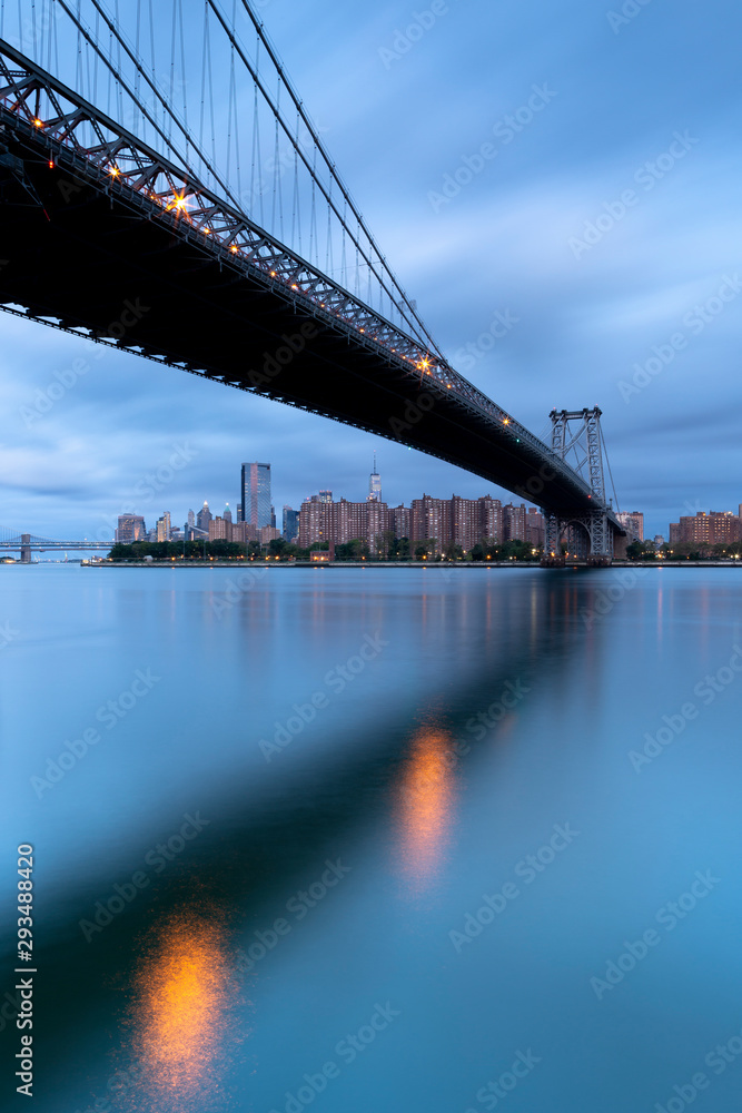 Obraz premium View on Williamsburg Bridge and Downtown Manhattan on a cloudy morning with long exposure