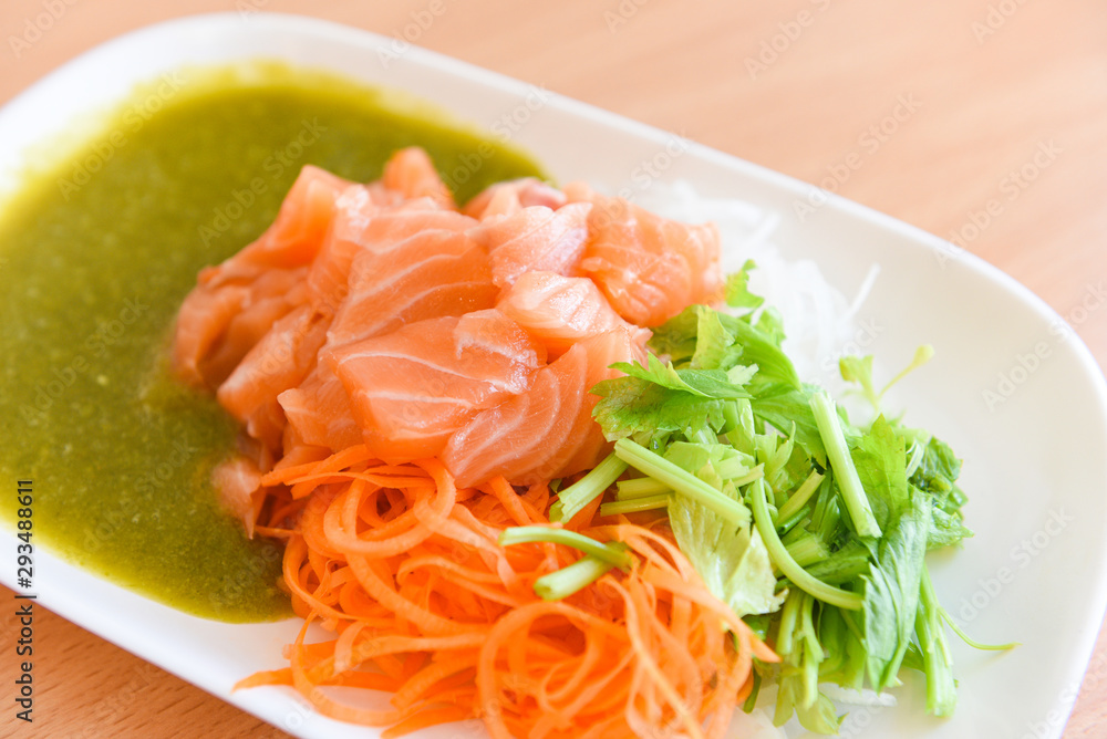 Japanese food raw sashimi salmon fillet with carrot celery seafood sauce in the restaurant / salmon salad menu set Japanese cuisine fresh ingredients on plate Japanese food raw sashimi salmon fillet with carrot celery seafood sauce in the restaurant / salmon salad menu set Japanese cuisine fresh ingredients on plate