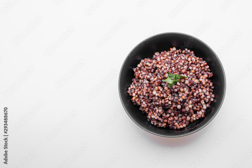 Cooked Sorghum (also known as sorgo) in a back bowl, isolated Cooked Sorghum (also known as sorgo) in a back bowl, isolated
