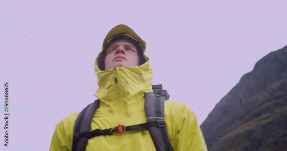 4K A Young Man Viewing The Glen Coe Scottish Mountains. A Student Tourist Yellow jacket and Backpack lost within natural rural spot in Scotland. 4K A Young Man Viewing The Glen Coe Scottish Mountains. A Student Tourist Yellow jacket and Backpack lost within natural rural spot in Scotland.