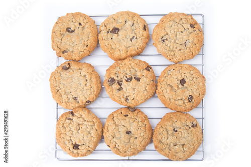 overhead view of freshly baked oatmeal raisin cookies on a cooling rack isolated on white
