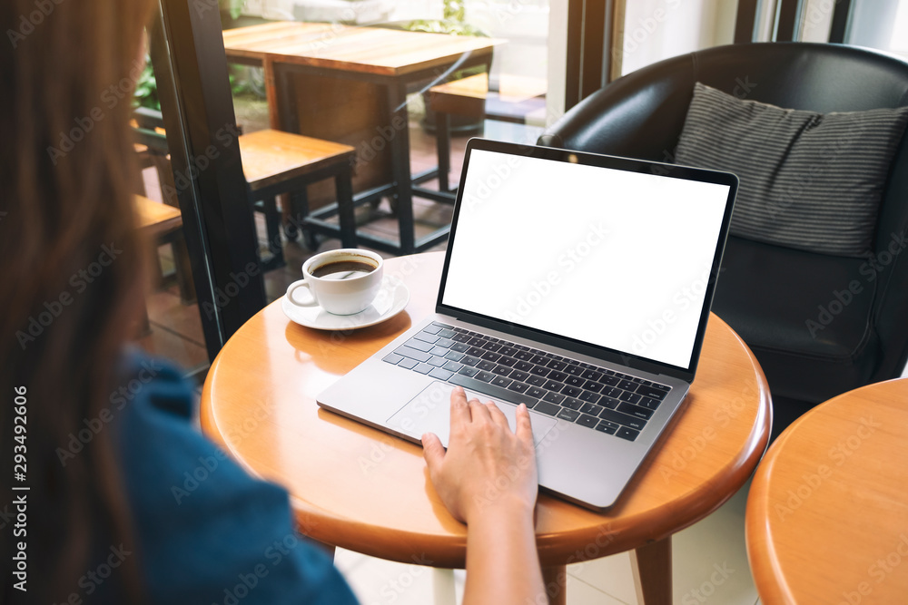Mockup image of a hand using and touching on laptop touchpad with blank white desktop screen while drinking coffee Mockup image of a hand using and touching on laptop touchpad with blank white desktop screen while drinking coffee