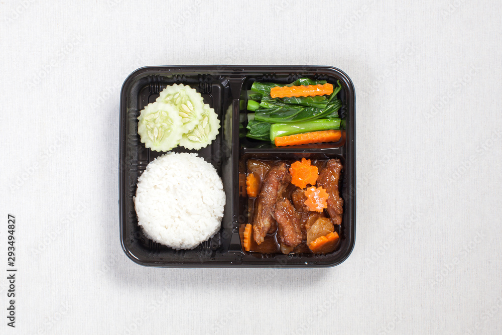 Baked pork rice put in a black plastic box, put on a white tablecloth, food box, Thai food. Baked pork rice put in a black plastic box, put on a white tablecloth, food box, Thai food.