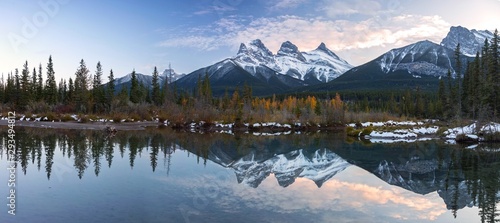 Three Sisters Snowy Mountain Peaks Reflection in Calm Water Wide Panoramic Landscape near Canmore, Alberta Foothills of Canadian Rocky Mountains photo