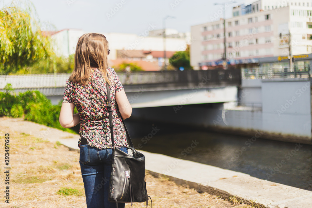 Rear view of woman walking alone on a sunny day Rear view of woman walking alone on a sunny day