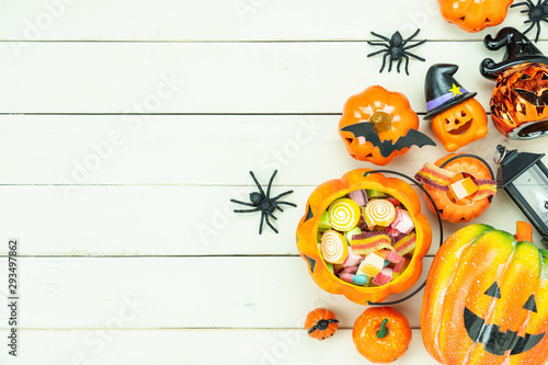Table top view aerial image of decorations Happy Halloween day background holiday concept.Flat lay objects to party pumpkins and spider with candy sweet on white wooden wallpaper.Copy space for text.