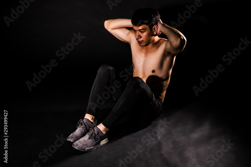 sport man at fitness gym club doing sit up exercise for body and showing muscle bodybuilding on black backgrounds, fitness concept, sport concept