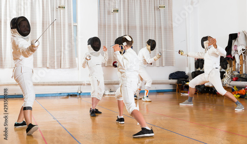 Boys with adults practicing fencing techniques