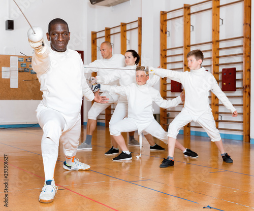 African American fencer practicing effective fencing techniques in training room