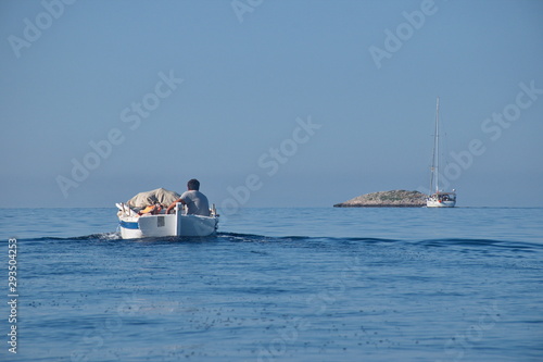 Rear view of wooden traditional boat with fisherman sailing on Adriatic sea © Vedrana
