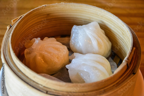 Dim sum dumplings served in small steamer basket.
