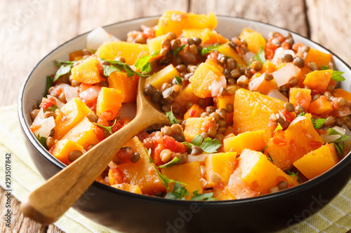 Spicy vegetable stew of pumpkins, tomatoes, lentils, onions and carrots close-up in a bowl. horizontal