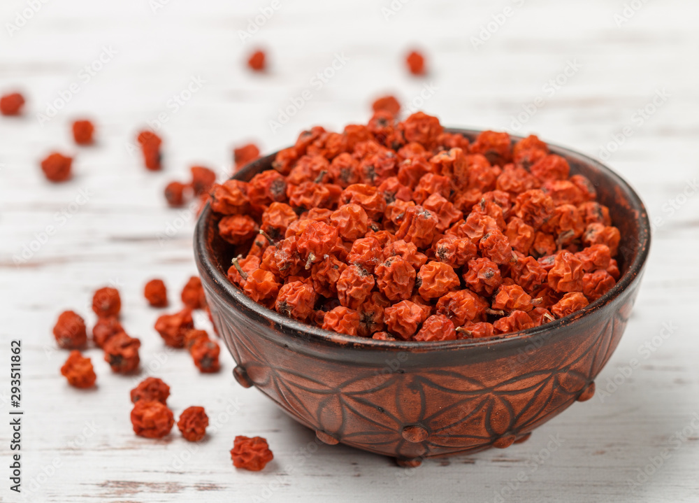 Dried Rowan berries in a ceramic bowl on a white table. Selective focus, copy space Dried Rowan berries in a ceramic bowl on a white table. Selective focus, copy space