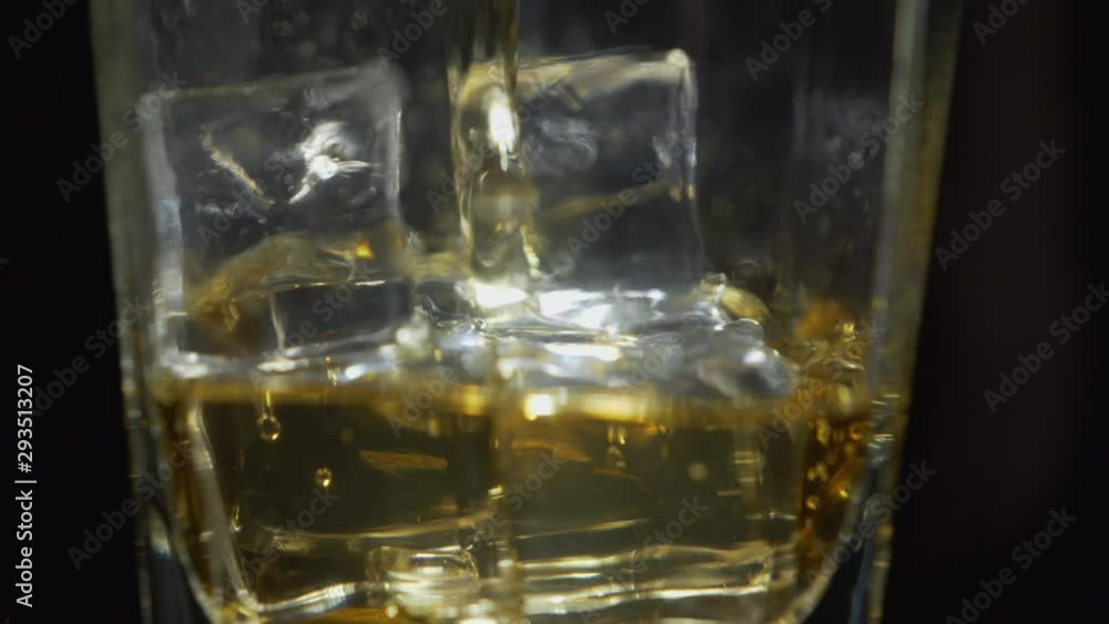 Whiskey on The Rocks Macro Close Up Slow Motion. Pouring Alcoholic Drink in Glass With Ice Cubes, Isolated With Black Background Whiskey on The Rocks Macro Close Up Slow Motion. Pouring Alcoholic Drink in Glass With Ice Cubes, Isolated With Black Background