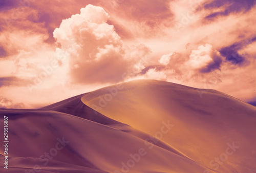 Beautiful gold sand dunes and sky with bright clouds in the Namib desert