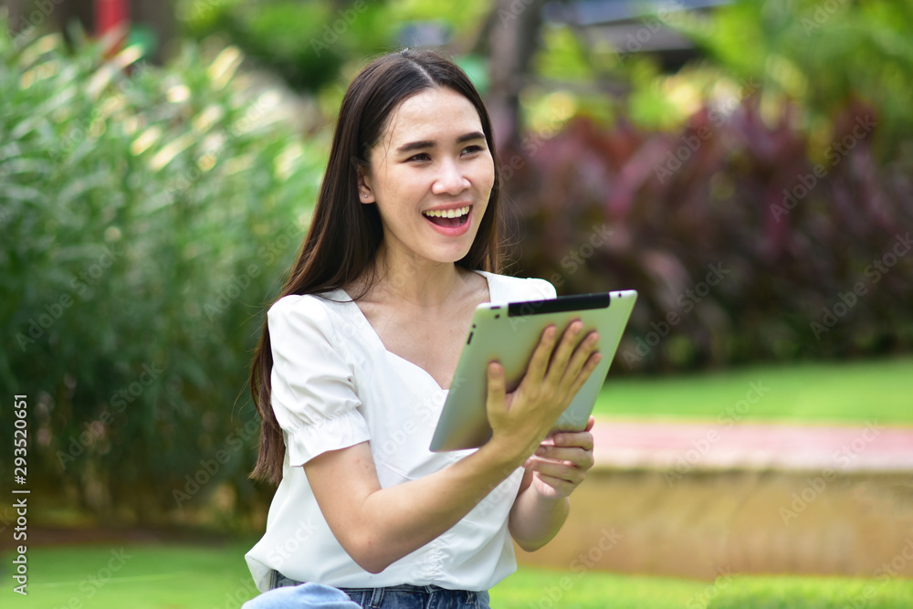 Women using tablet filling happy smile to shopping online at city park Women using tablet filling happy smile to shopping online at city park