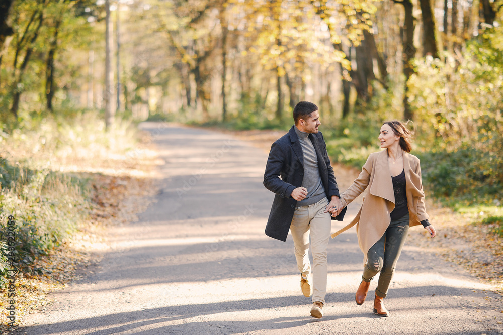 lovely couple walking around the park during autumn lovely couple walking around the park during autumn