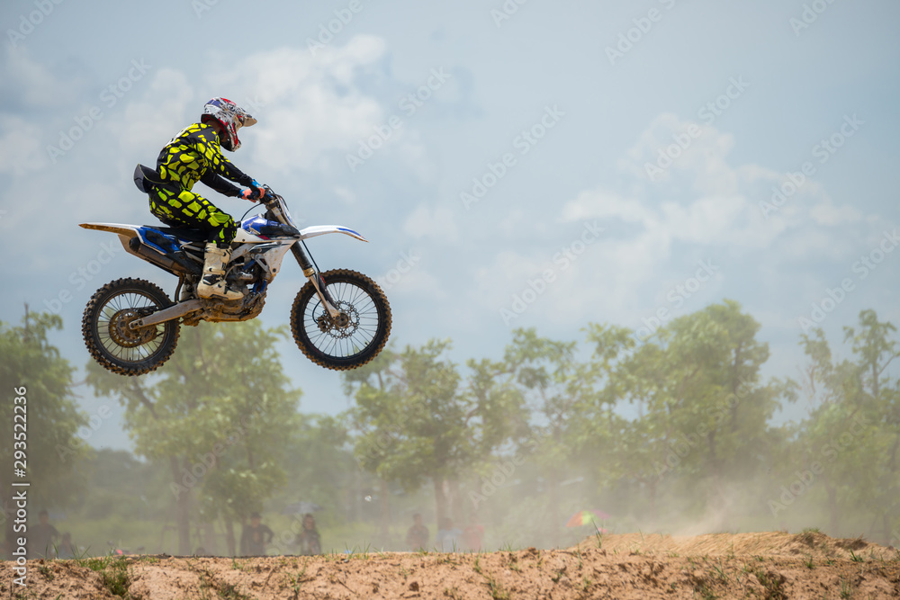 Naklejka premium Motocross Rider Jump in a blue sky with clouds.Enduro bike rider in action. 