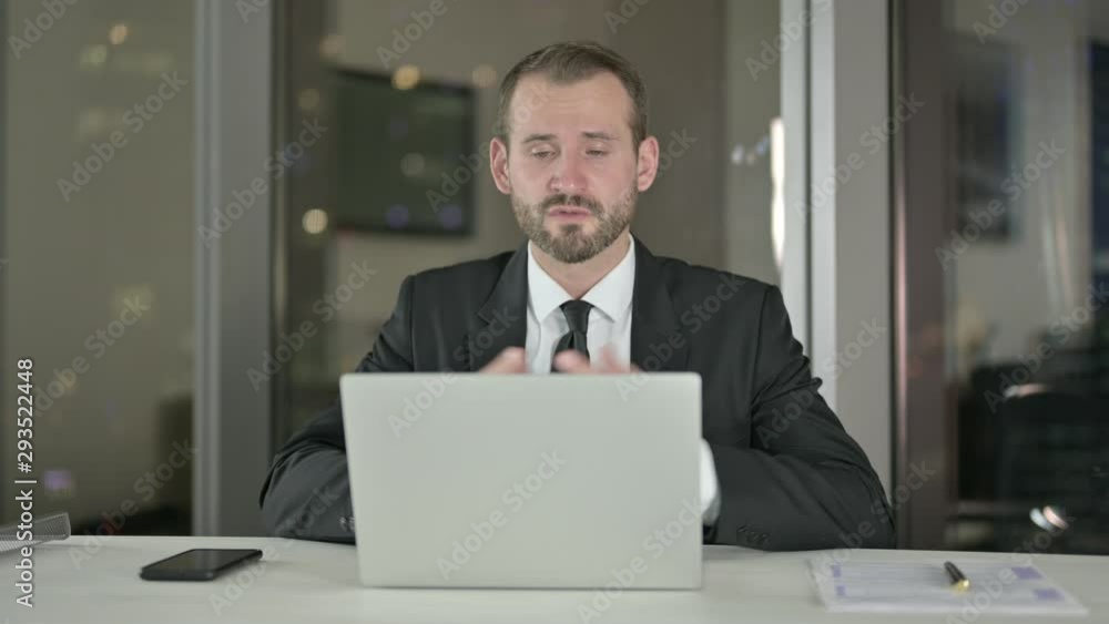Ambitious Businessman doing Video Chat on Laptop at Night Ambitious Businessman doing Video Chat on Laptop at Night