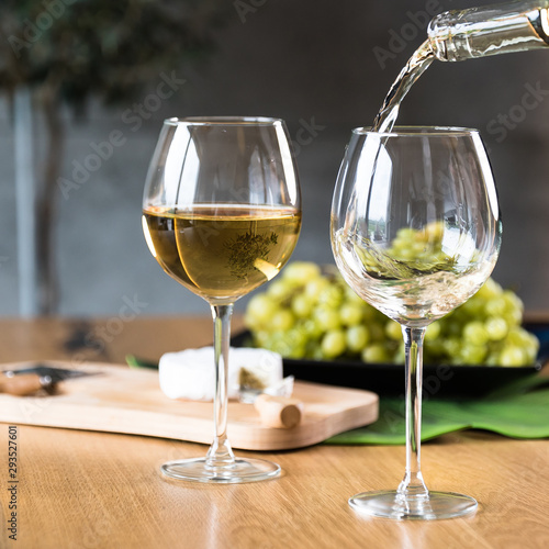 Waiter pouring white wine into wineglass. 