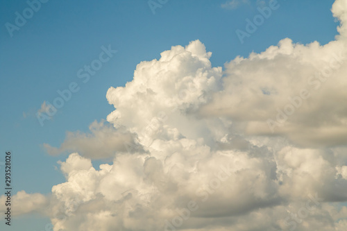 White powerfully cumulus clouds on a blue sky.