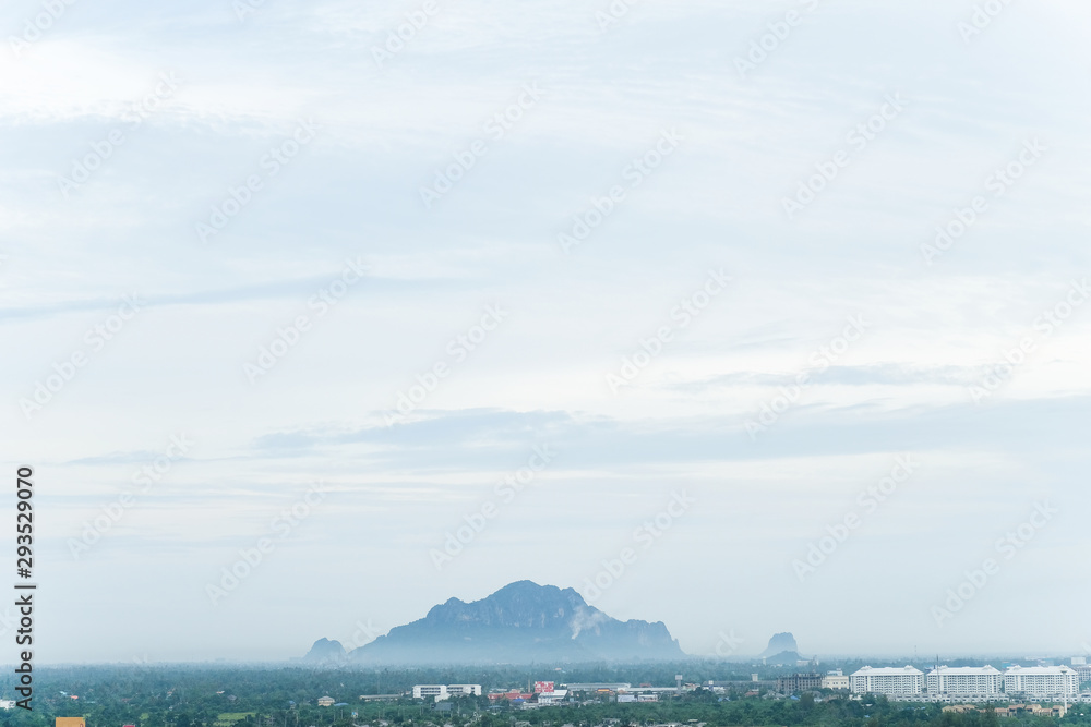 Cityscape view over blue clouds sky ,look at Khao Nang Phanthurat mountain with forest behind the morning mist in Cha-am, Petchaburi, Thailand