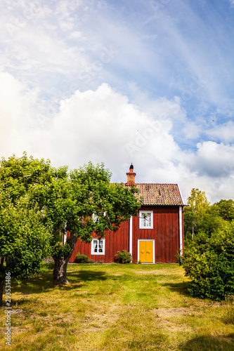 Schwedisches Haus mit roter Fassade in schönem Garten. Scandinavian house on countryside. Red old wooden house. photo