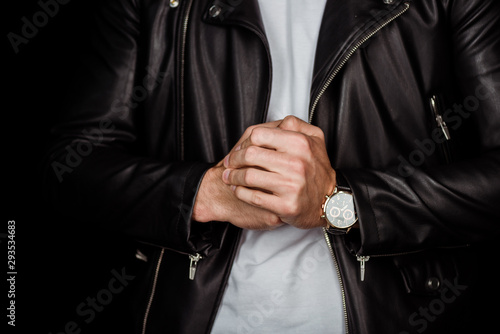 cropped view of stylish young man in leather jacket with clenched hands isolated on black
