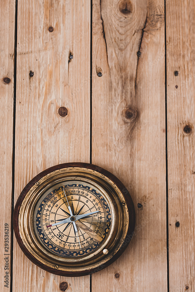 OLD COMPASS ON RUSTIC WOOD BACKGROUND. TRAVEL THE WORLD OLD COMPASS ON RUSTIC WOOD BACKGROUND. TRAVEL THE WORLD