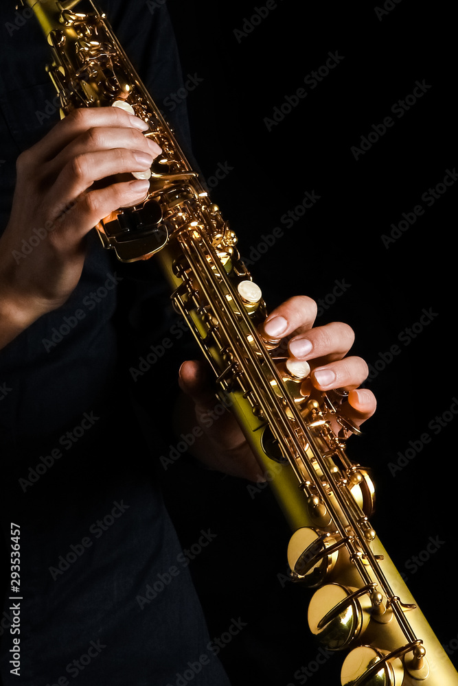 Obraz premium soprano saxophone in hands on a black background