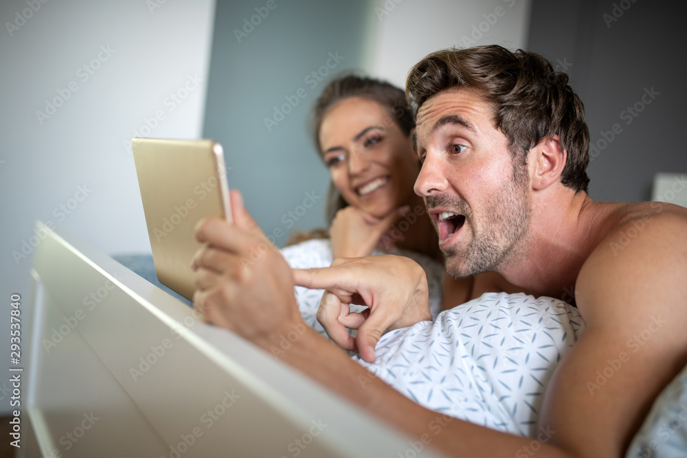 Happy couple spending free time on a tablet at home. Happy couple spending free time on a tablet at home.