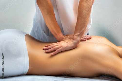 Physiotherapist applying pressure with hands on female bac