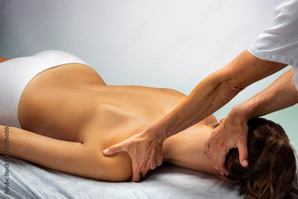 Fototapeta premium Physiotherapist manipulating neck and shoulder on female patient.