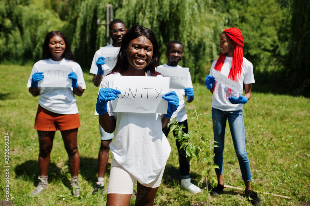 Group of happy african volunteers hold blank board with unity sign in park. Africa volunteering, charity, people and ecology concept. Group of happy african volunteers hold blank board with unity sign in park. Africa volunteering, charity, people and ecology concept.