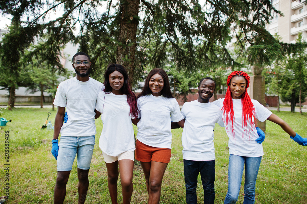 Group happy african volunteers hugs together in park. Africa volunteering, charity, people and ecology concept. Group happy african volunteers hugs together in park. Africa volunteering, charity, people and ecology concept.