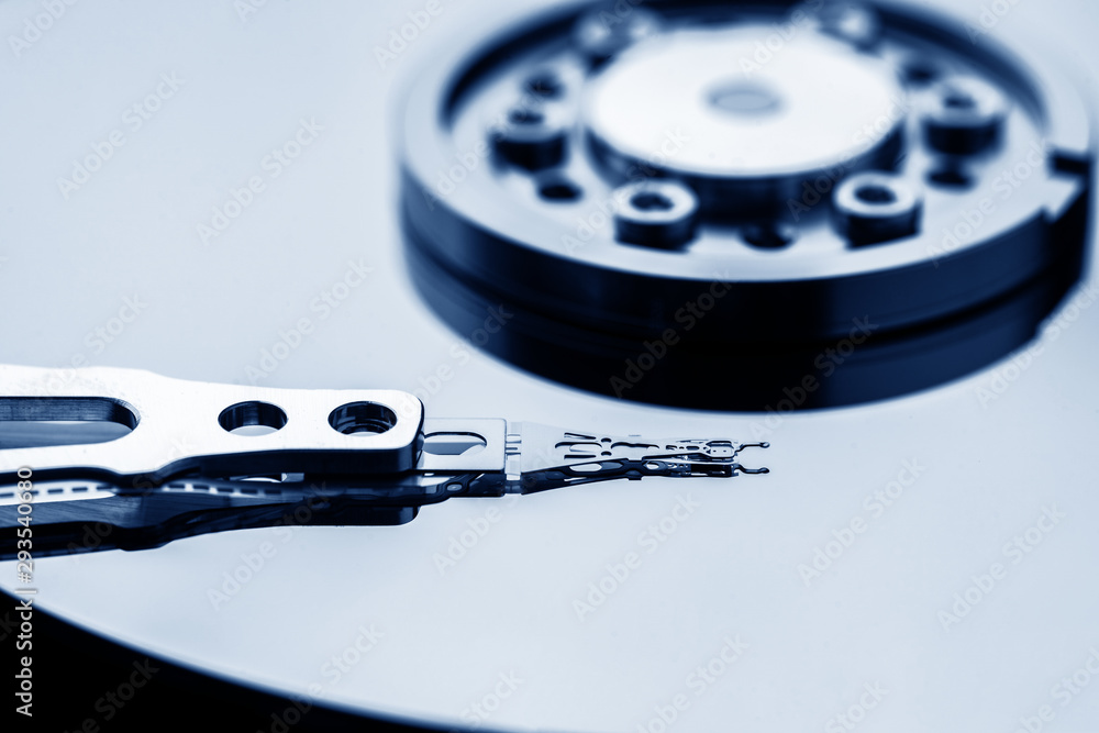 Closeup macro photo of head in opened hard disk drive. Concept of repair or recovery information from broken HDD.