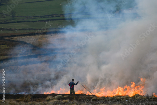 Fotografie Farmer beating fire to control burning of heather [3]