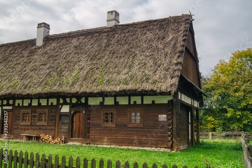 stara drewniana chałupa wiejska kryta słomianą strzechą, małe okna wiejskiego domu,