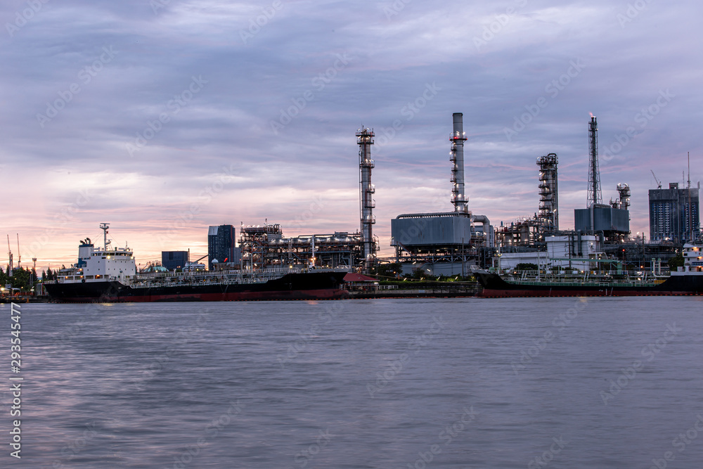 Petroleum oil refinery plant beside river in twilight time. Crude Oil Process machinery