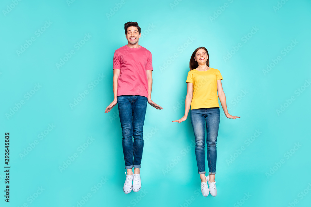 Full length body size view of nice attractive lovely cute funky cheerful cheery modest couple jumping in air having fun time isolated on bright vivid shine vibrant green turquoise background