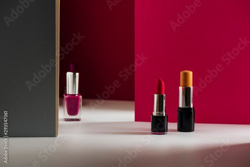 lipstick, Concealer bar and nailpolishes on modern pink background. Product and cosmetics © saquizeta