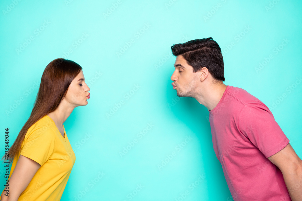 Profile side view portrait of his he her she nice attractive dreamy affectionate couple leaning kissing isolated over bright vivid shine vibrant green turquoise background Profile side view portrait of his he her she nice attractive dreamy affectionate couple leaning kissing isolated over bright vivid shine vibrant green turquoise background