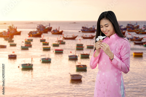 Portrait Vietnamese Woman in dress traditional and Mui Ne Fishing village background