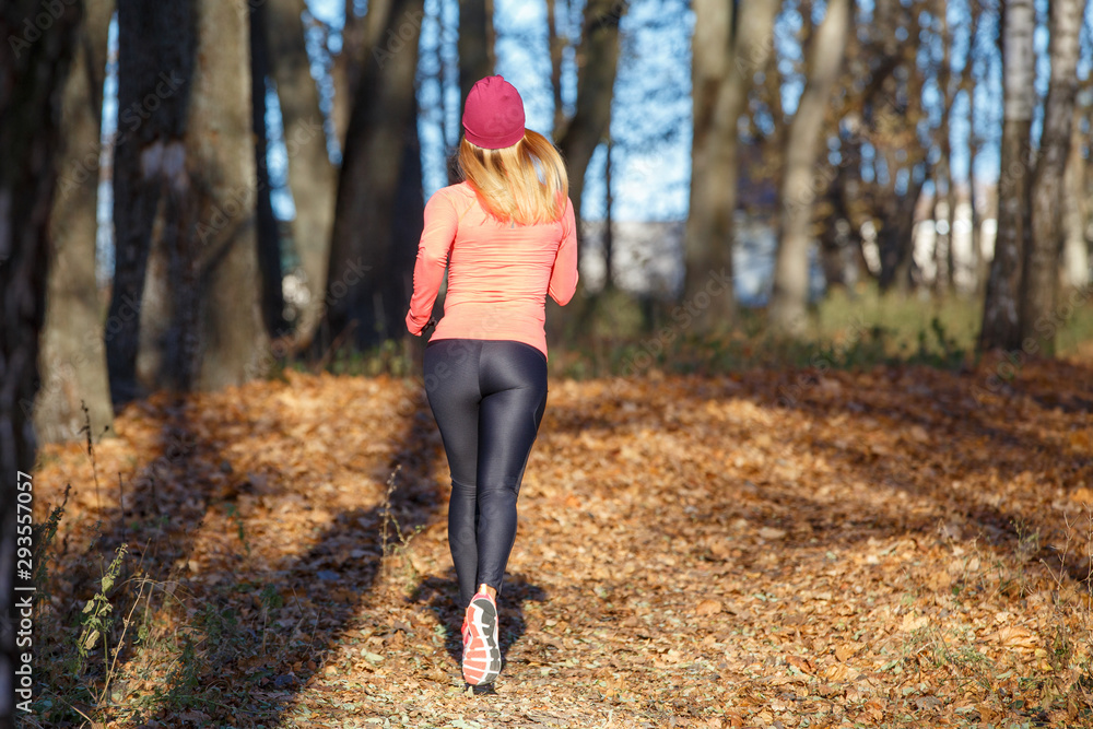 Back view of running girl in fall park in morning Back view of running girl in fall park in morning