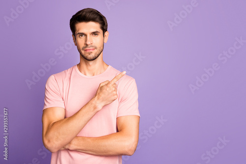 Portrait of his he nice attractive handsome brunet bearded guy wearing pink tshirt pointing forefinger aside follow subscribe isolated over violet purple lilac pastel color background
