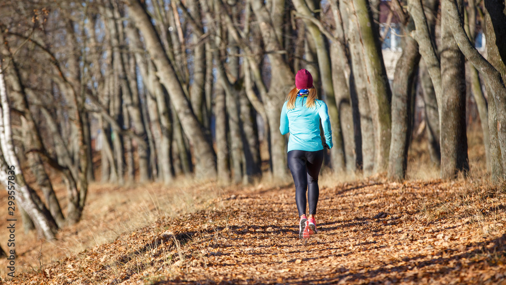 Back view of running girl in fall park in morning Back view of running girl in fall park in morning