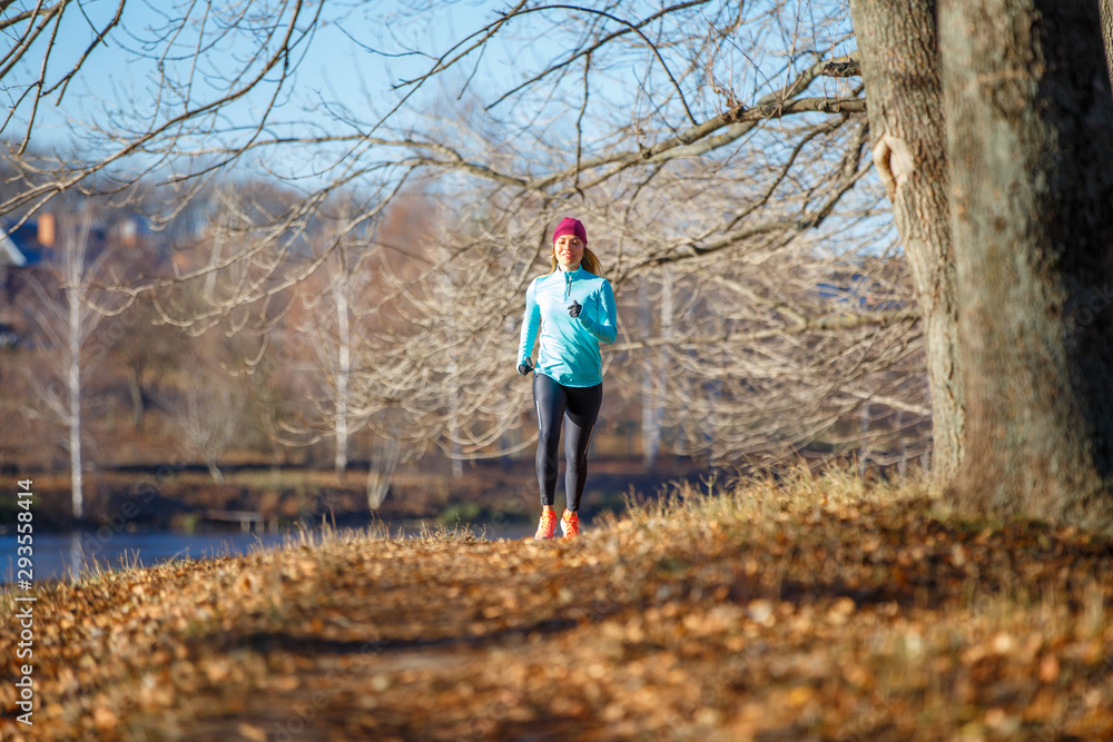 Young woman running training in autumn park Young woman running training in autumn park
