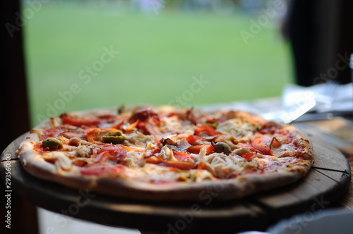 Pizza with olives on a wooden plate