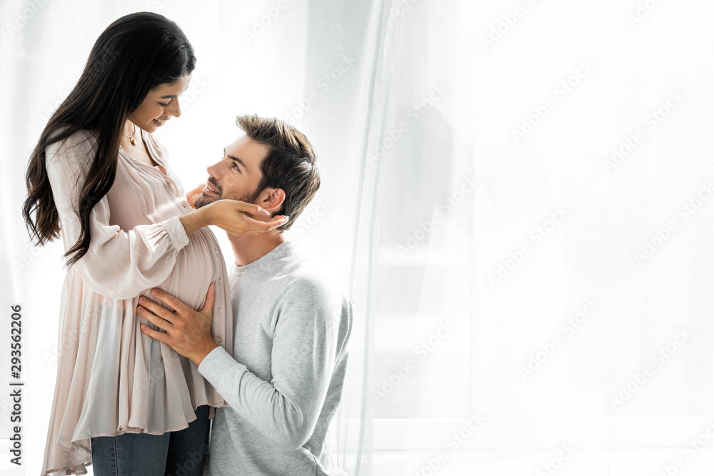 handsome man hugging belly of his pregnant african american woman